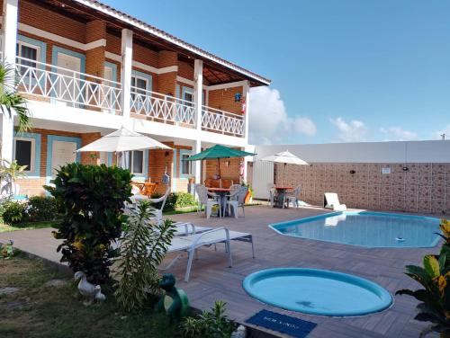 um pátio com uma piscina e uma casa em Torre do Sol em Praia do Francês