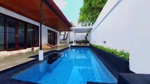 a swimming pool in front of a house at Private Pool Villas Kuta Bali in Kuta
