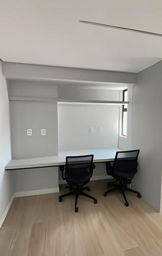 an office with two chairs and a white desk at Loft luxo p/ 4 pessoas, a 50m do mar in Ilha da Restinga