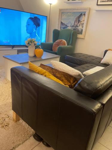 un salon avec un canapé en cuir et une table dans l'établissement Appartement Paris 10e Arrondissement, à Paris