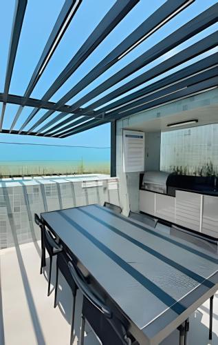 a table on the balcony of a house at Loft luxo p/ 4 pessoas, a 50m do mar in Ilha da Restinga
