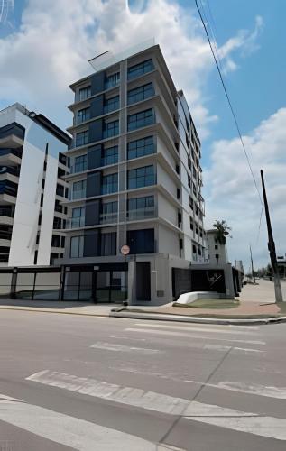 a tall building on the corner of a street at Loft luxo p/ 4 pessoas, a 50m do mar in Ilha da Restinga