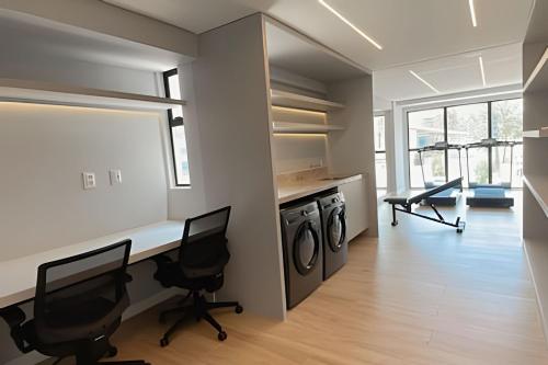 a home office with a desk and two chairs at Loft luxo p/ 4 pessoas, a 50m do mar in Ilha da Restinga