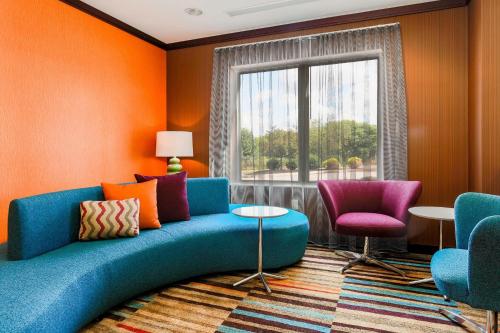 a living room with a blue couch and two chairs at Fairfield by Marriott Wilkes-Barre in Wilkes-Barre