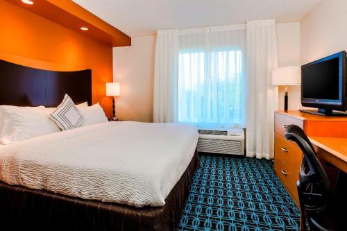 a hotel room with a bed and a flat screen tv at Fairfield by Marriott Wilkes-Barre in Wilkes-Barre