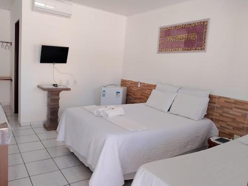 een hotelkamer met twee bedden en een televisie bij Torre do Sol in Praia do Frances