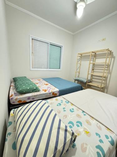a bedroom with two beds and a window at Casa Carvalho in Peruíbe
