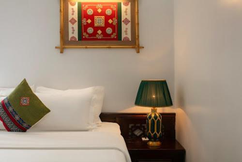 a bedroom with a bed and a lamp on a table at Sapa Mountain Queen House in Sapa