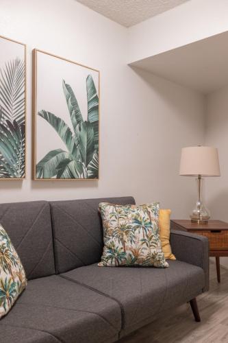 a gray couch in a living room with two pictures at Bishop Suites at Executive Centre in Honolulu