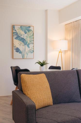 a living room with a couch with a yellow blanket at Bishop Suites at Executive Centre in Honolulu