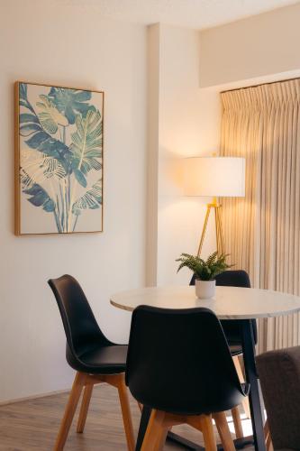 a table and chairs in a room with a lamp at Bishop Suites at Executive Centre in Honolulu