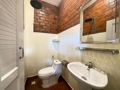 a small bathroom with a toilet and a sink at The Last Beach House in Kampot