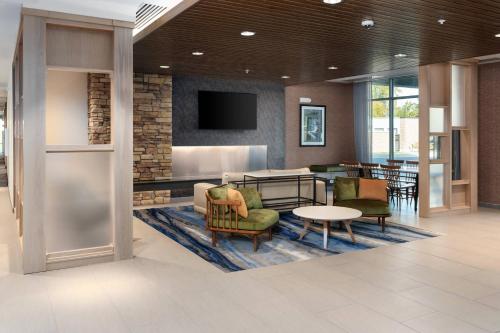 a lobby with chairs and a table and a tv at Fairfield Inn & Suites Morganton Historic Downtown in Morganton