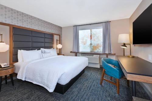 a hotel room with a large bed and a desk at Fairfield Inn & Suites by Marriott Kalamazoo in Kalamazoo