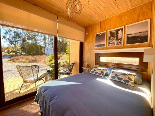 a bedroom with a bed and a large window at Lodge Las Luces de Algarrobo in Algarrobo