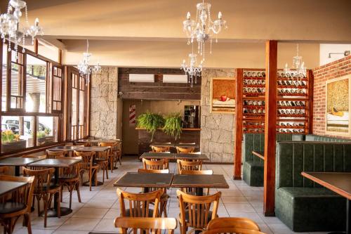 a restaurant with wooden tables and chairs and chandeliers at Coronado Hotel in Mina Clavero