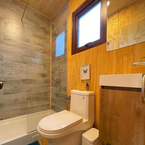 a bathroom with a toilet and a glass shower at Lodge Las Luces de Algarrobo in Algarrobo