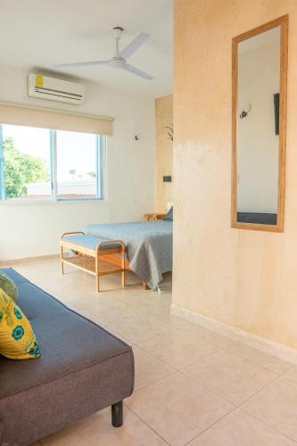 a living room with a bed and a mirror at Casa privada con alberca grande in Chetumal