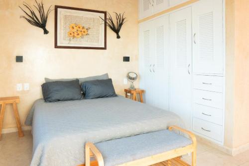 a bedroom with a bed with a bench next to it at Casa privada con alberca grande in Chetumal