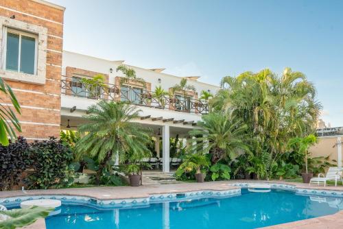 a house with a swimming pool and palm trees at Casa privada con alberca grande in Chetumal