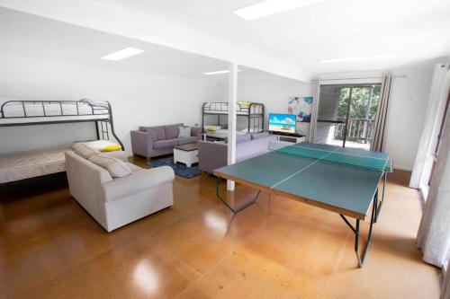 sala de estar con mesa de ping pong y literas en A Wood Haven, en Metung