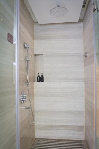 a bathroom with a shower with a glass door at Expo Center Hotel - Free Shuttle Bus & Late Check-out in Yiwu