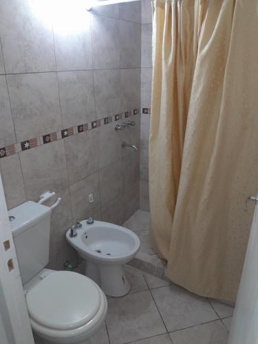 a bathroom with a toilet and a shower with a shower curtain at Abuela Betty in Villa Carlos Paz
