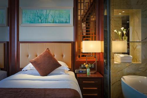 a bedroom with a bed and a lamp and a sink at Expo Center Hotel - Free Shuttle Bus & Late Check-out in Yiwu