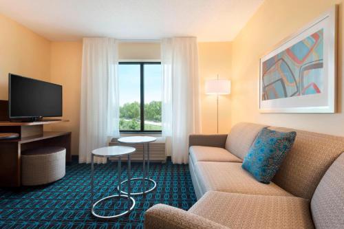 a hotel room with a couch and a television at Fairfield Inn & Suites Hartford Manchester in Manchester