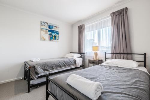 a bedroom with two beds and a window at Ocean Vista in Lakes Entrance