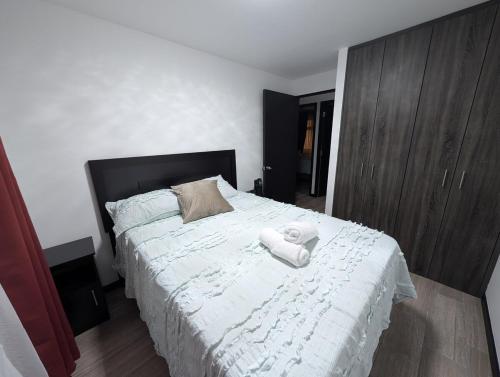 a bedroom with a bed with two towels on it at Departamento zona 12 Guatemala in Boca Monte