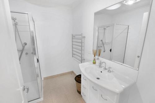 un bagno bianco con lavandino e doccia di Sea Breeze a Paynesville