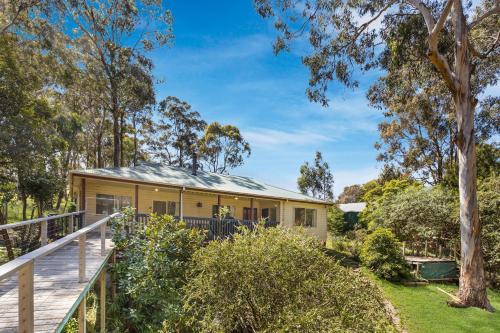 a house in the bush with a deck at Lakes Edge in Lakes Entrance