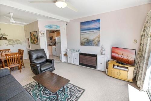 a living room with a couch and a tv at Magpie Cottage in Paynesville