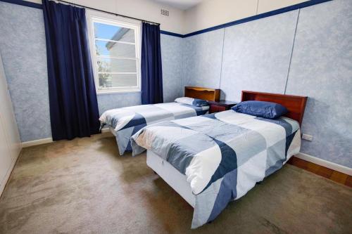 Un dormitorio con dos camas y una ventana. en Kalimna Holiday House, en Kalimna