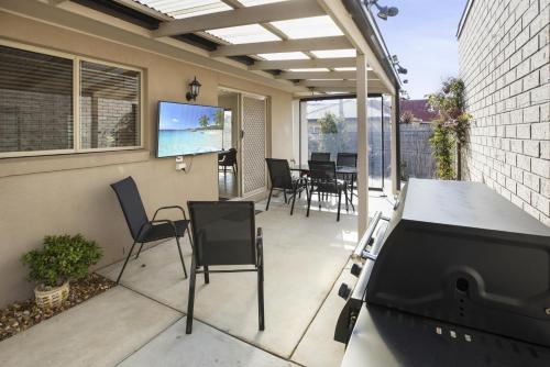 a screened in porch with chairs and a tv at Paynesville Villa in Paynesville