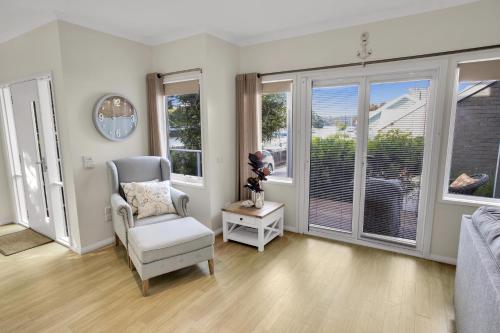 a living room with a chair and windows at Bliss by the Bay in Metung