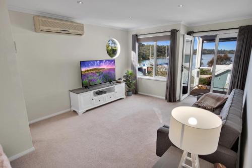 a living room with a tv and a couch at Bliss by the Bay in Metung