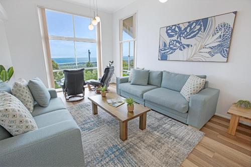 a living room with a blue couch and a table at Sea Haven in Lakes Entrance
