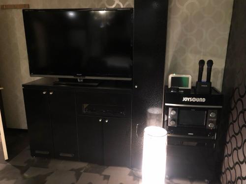 a black entertainment center with a flat screen tv at X Hotel - Adult Only- in Sayama