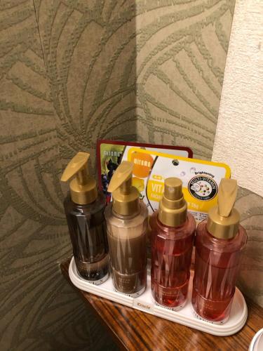 four bottles of condiments on a tray with a box at X Hotel - Adult Only- in Sayama