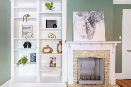 una sala de estar con chimenea y estanterías blancas en Stylish Retreat Walkable to Bars & Restaurants, en Louisville