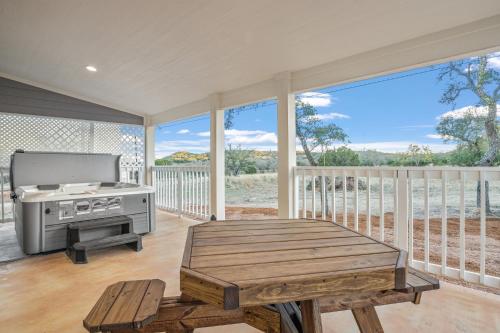 a screened in porch with a grill and a table at Appian Way Maltese Cottage in Fredericksburg