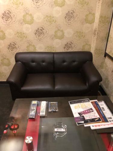 a leather couch in a living room with a table at X Hotel - Adult Only- in Sayama