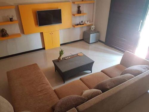a living room with a couch and a tv at The Royen - Oaza in Lovina in Lovina