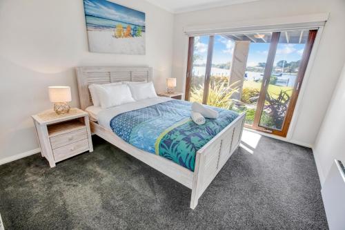 Un dormitorio con una cama y una ventana grande. en Lake King Lakehouse, en Paynesville