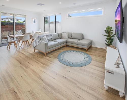 a living room with a couch and a table at Banyandah on the Lakes in Paynesville