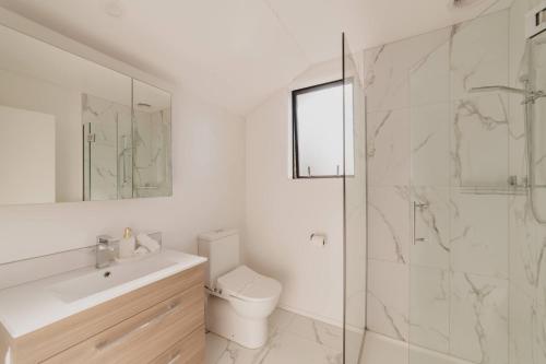 a bathroom with a toilet and a sink and a shower at Designer 2BR Flat - Outdoor Sitting & Cozy Ambiance in Christchurch