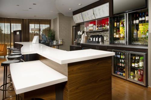 a bar with a white counter and bottles of alcohol at Courtyard by Marriott San Antonio SeaWorld/Lackland in San Antonio