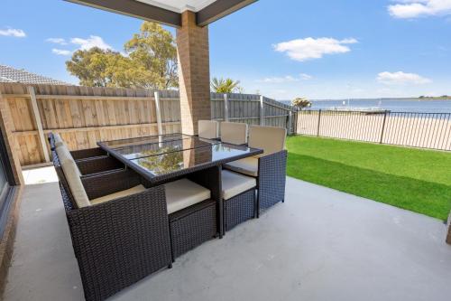 a patio with a table and chairs and a lawn at Lake Views Retreat in Paynesville
